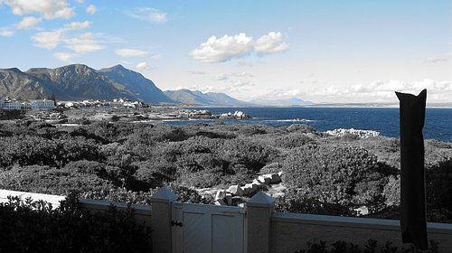 A black and white photo of a view of the ocean and mountains