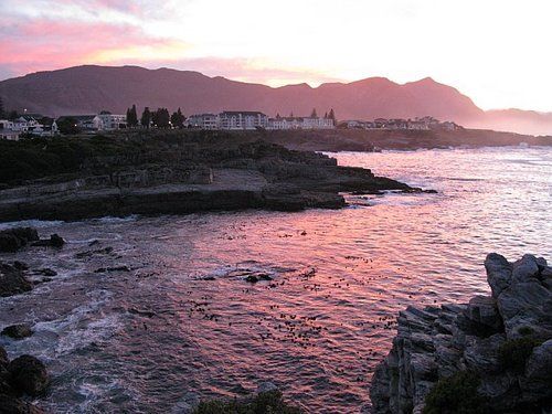 A sunset over a body of water with mountains in the background
