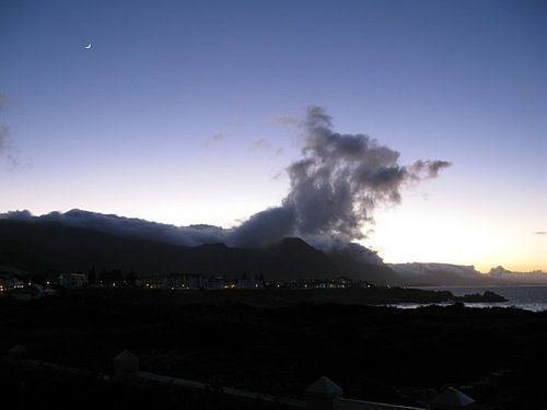 A sunset over a city with mountains in the background