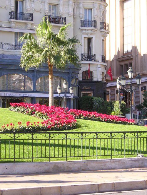 A large building with a fence and flowers in front of it