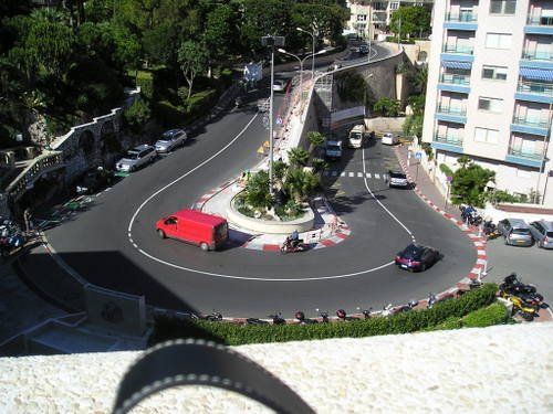 A red van is driving through a roundabout in a city