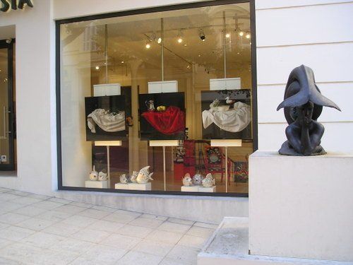 A statue sits in front of a store window that says sia