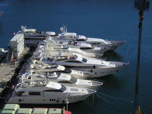 A row of boats are docked in a harbor