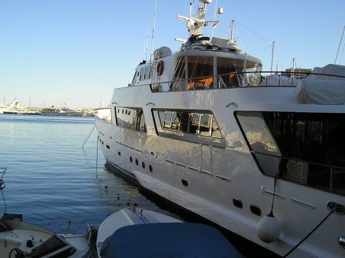 A large white yacht is docked in the water