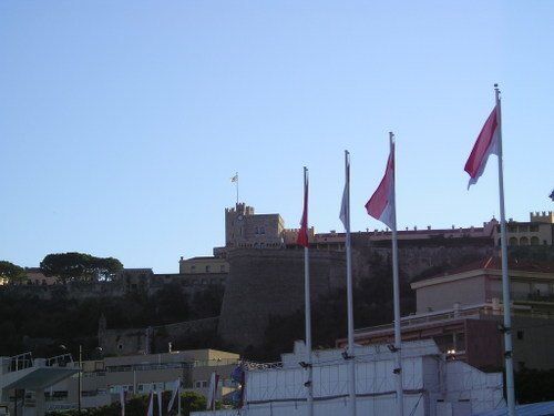 Several flags are flying in front of a castle