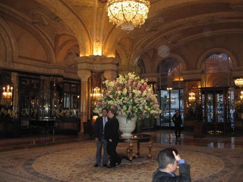 A man is taking a picture of two people in a hotel lobby