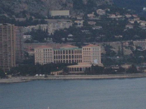 A large building sits on the shore of a body of water