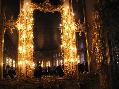A large mirror with candles on it in a dark room