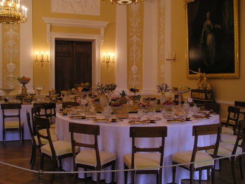 A large dining room with a round table and chairs