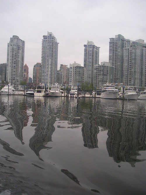 A city skyline is reflected in a body of water