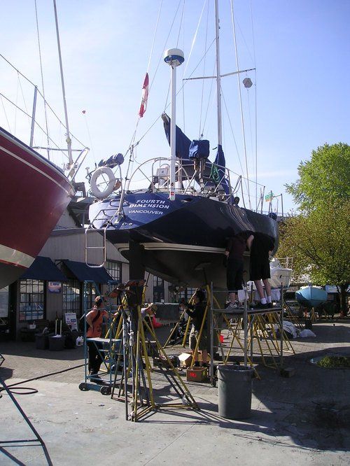 A boat with a blue sail is being worked on