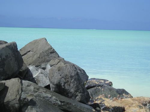 A large body of water with rocks in the foreground