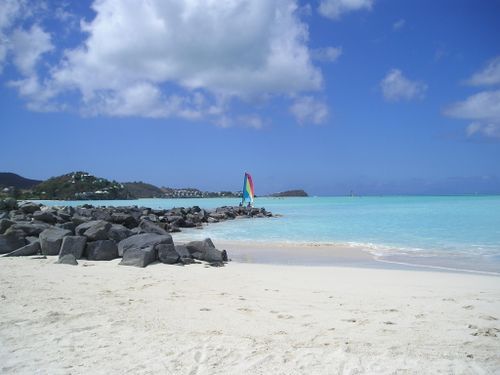 A beach with a sailboat in the distance