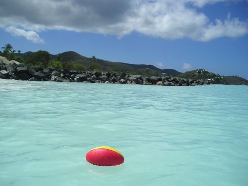 A red and yellow ball is floating in the ocean
