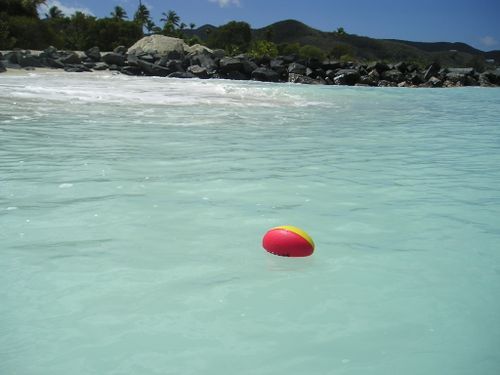 A red and yellow beach ball is floating in the ocean