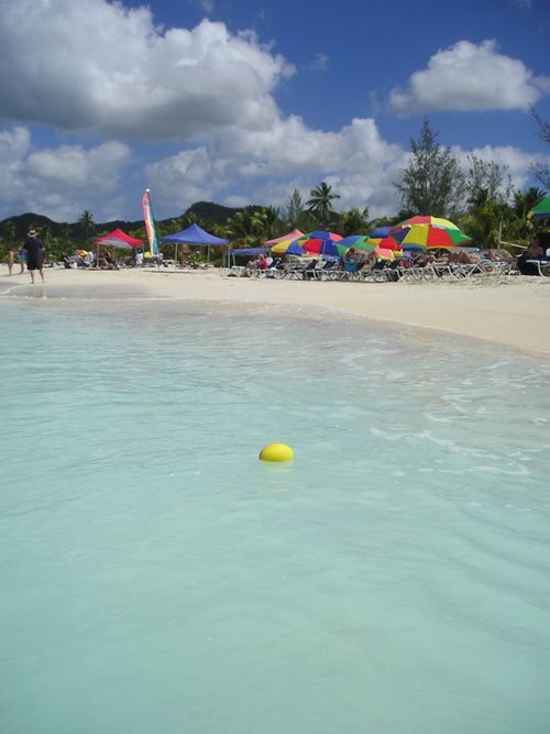 A yellow ball is floating in the water on a beach