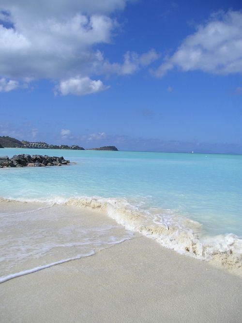 A white sandy beach with a blue ocean in the background