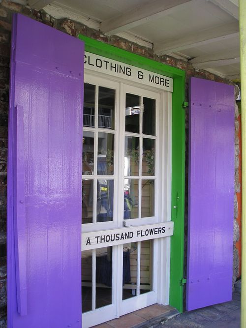 A store front with purple shutters and a sign that says a thousand flowers