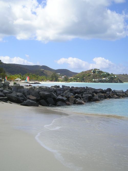A beach with rocks and mountains in the background