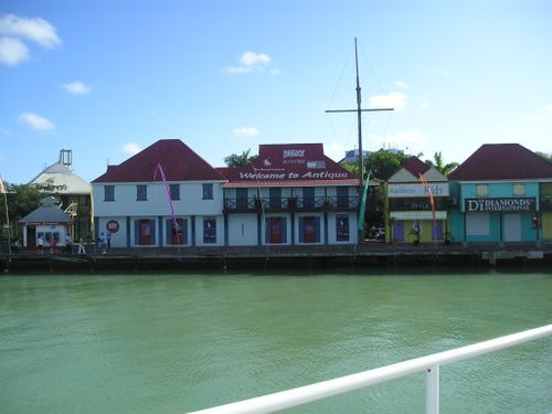 A building with a red roof is next to a body of water