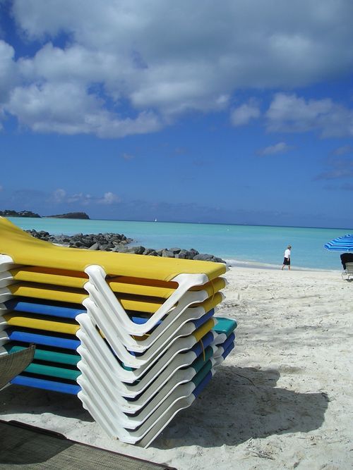 A stack of beach chairs on a sandy beach