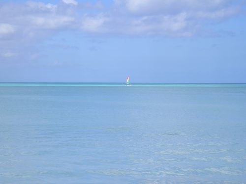 There is a sailboat in the middle of the ocean.