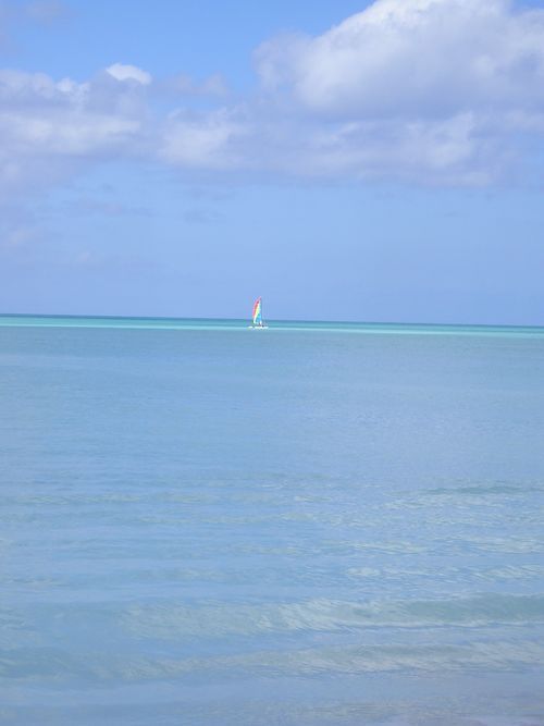 A sailboat is floating on top of a large body of water.