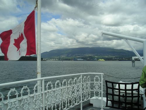 A canadian flag is flying over a body of water
