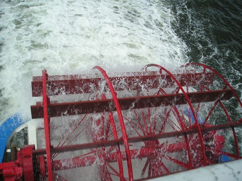 A red and white ferris wheel is floating in the water