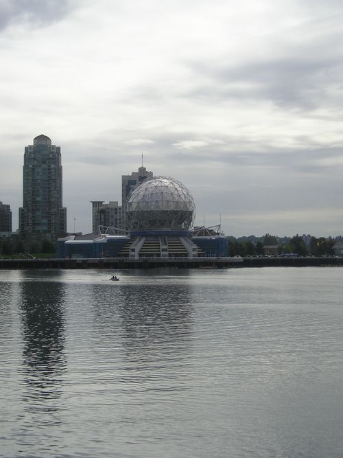 A large dome shaped building is in the middle of a body of water.