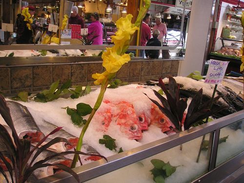 A display of fish and flowers with a sign that says 1000 pesos
