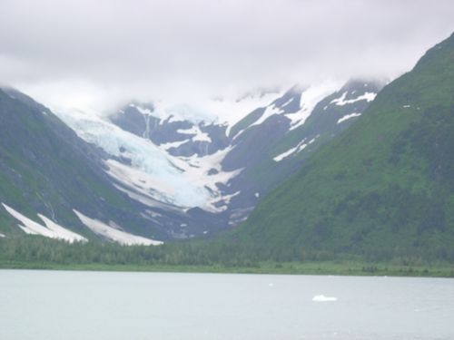 A lake surrounded by mountains with snow on them