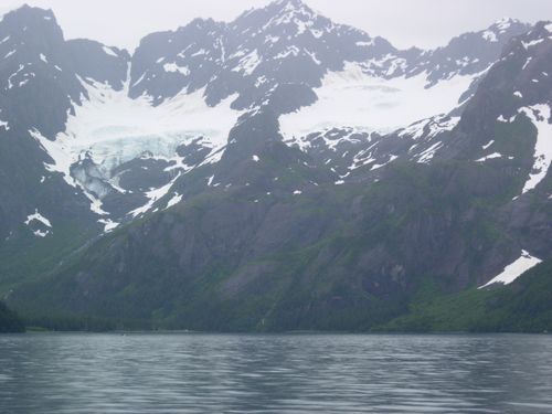A lake with mountains in the background and a glacier in the foreground