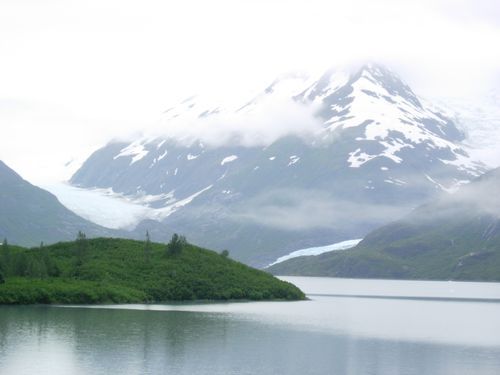 A lake with mountains in the background and a small island in the middle