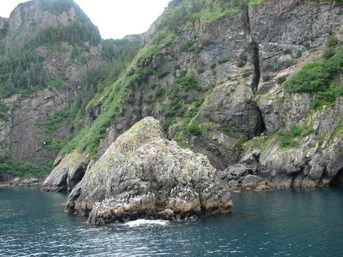 A large rock in the middle of a body of water