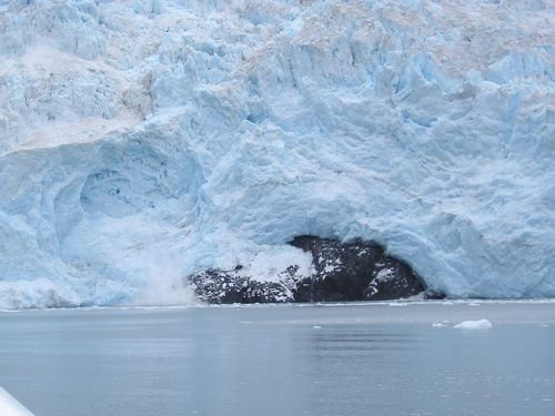 A large iceberg is sitting in the middle of a body of water.