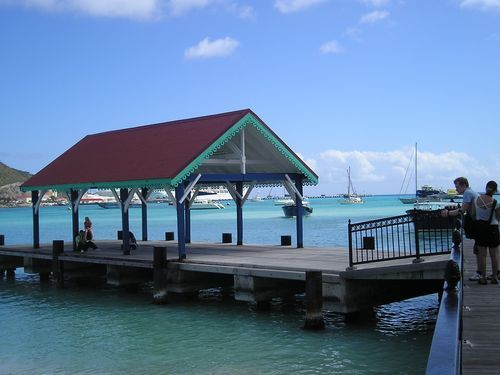 People standing on a dock with boats in the background
