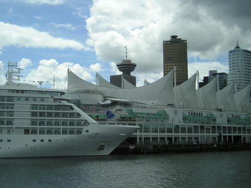 A large cruise ship is docked in front of a building that says canada