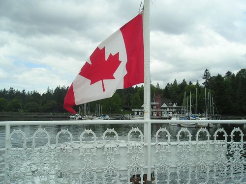 A canadian flag is flying over a body of water