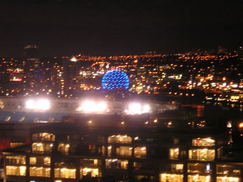 A city at night with a blue ball in the middle