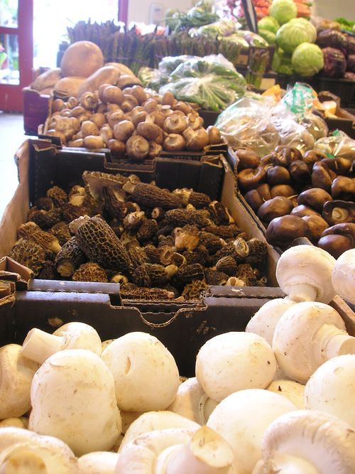 A display of mushrooms and other vegetables in a store