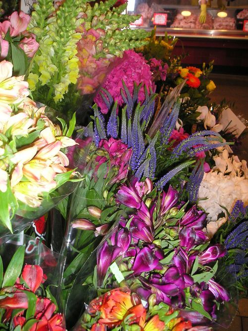 A bunch of different colored flowers are sitting on a table
