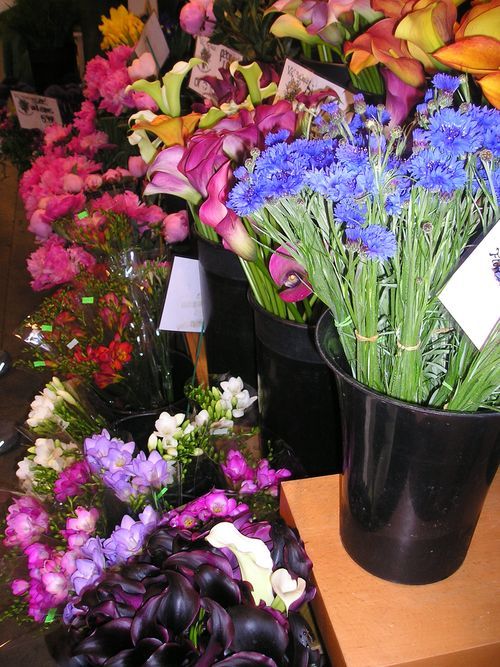 A bunch of flowers in a black vase with a tag on it