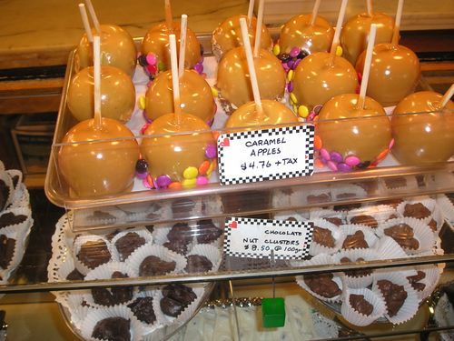 A tray of caramel apples with candy on them