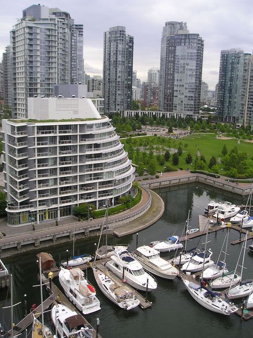 A bunch of boats are docked in a harbor in a city
