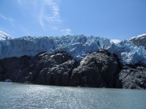 A large glacier is surrounded by a body of water