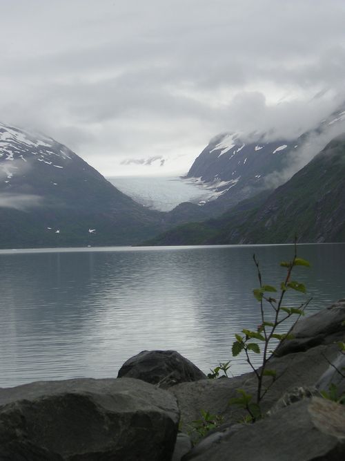 A lake with mountains in the background and rocks in the foreground