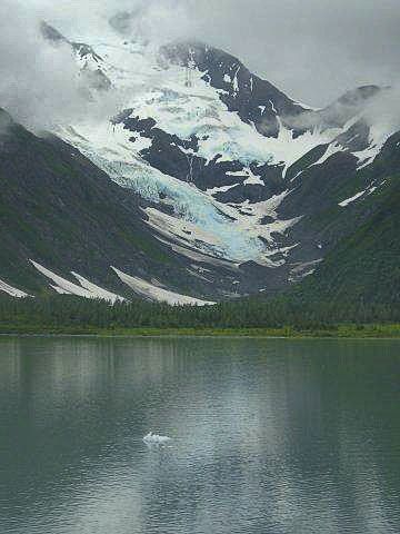 A mountain covered in snow is reflected in a lake.