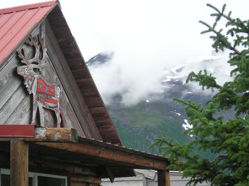 A statue of a deer on the side of a building with mountains in the background