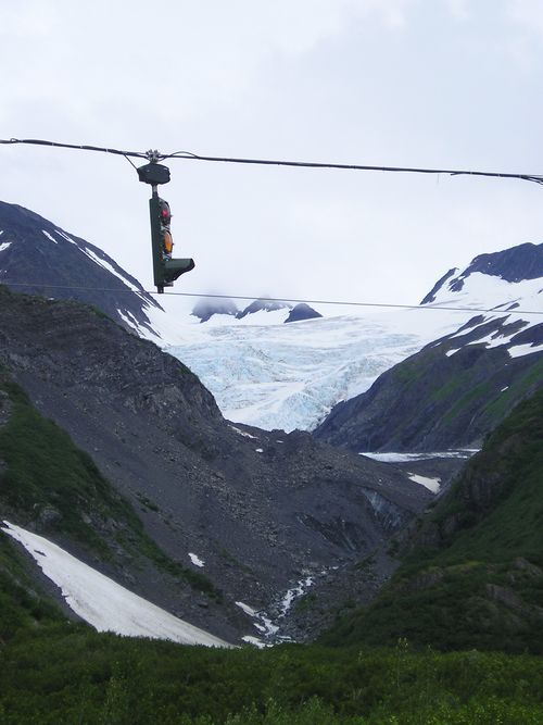 A cable car going up a mountain with a glacier in the background